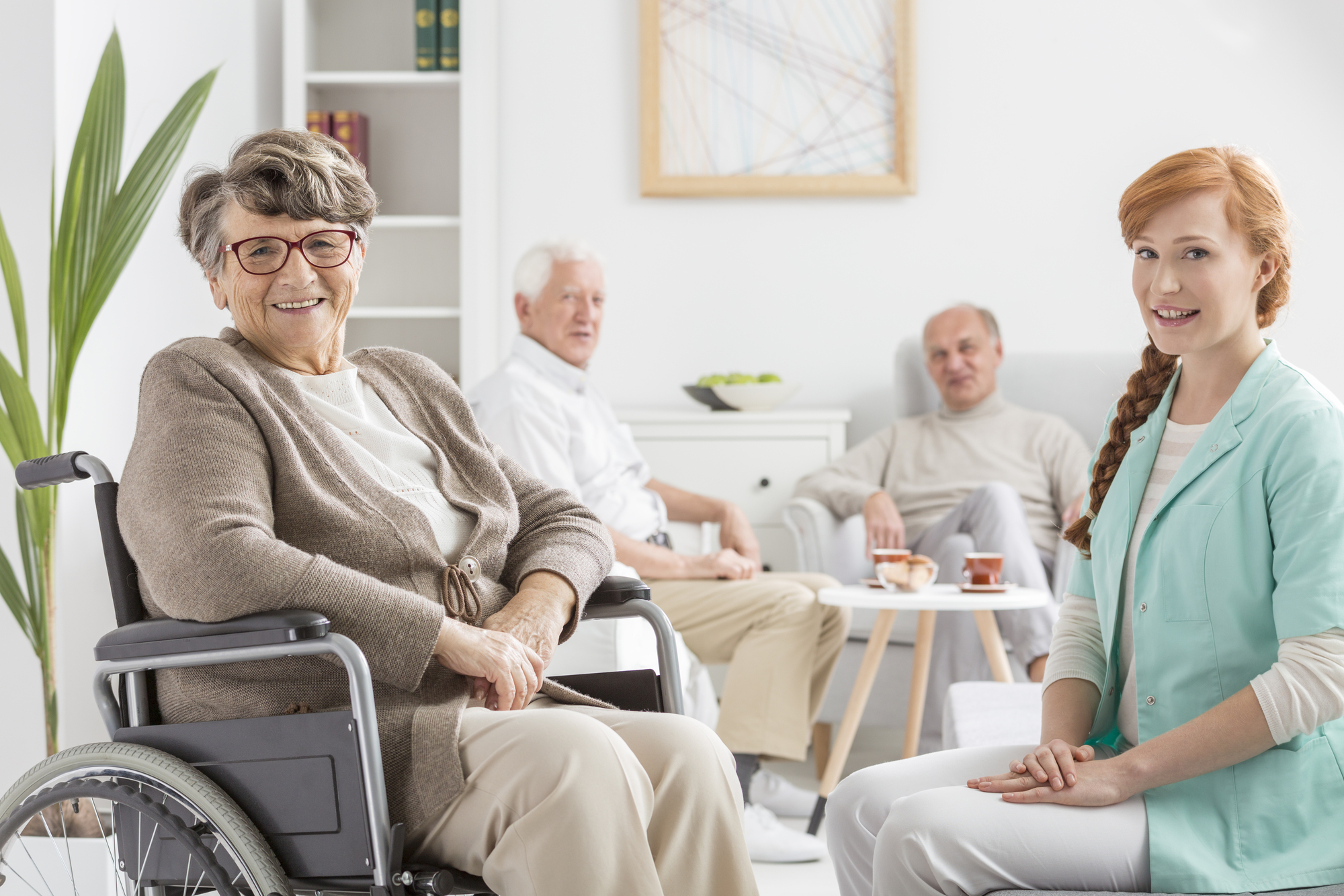Senior on a wheelchair with young nurse