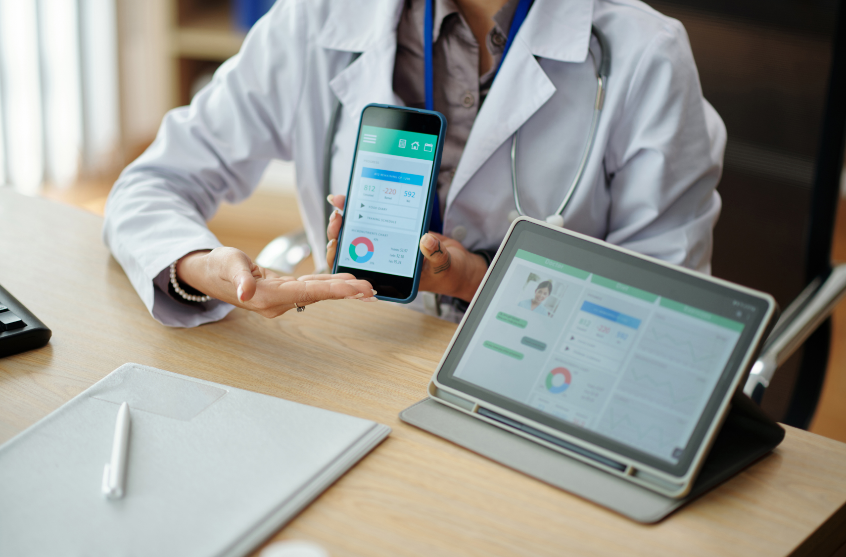 A healthcare professional in a lab coat displays health data on a smartphone, while a tablet shows patient information, emphasizing digital health management.