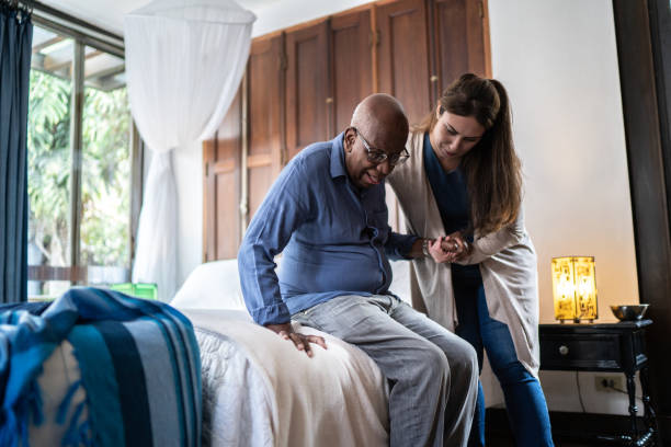 Female caretaker measuring senior woman's blood pressure at home